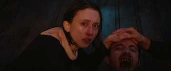 Movie still from “The Nun II” (2023), directed by Michael Chaves – A young woman is crying while sitting on a man's shoulder; Close Up shot, Overhead angle