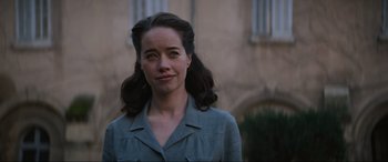 Movie still from “The Nun II” (2023), directed by Michael Chaves – A young woman with long dark brown hair; Close Up shot, Over the shoulder angle