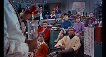 Movie still from “The Nutty Professor” (1963), directed by Jerry Lewis – A group of people sitting in a room; Wide shot, High angle