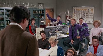 Movie still from “The Nutty Professor” (1963), directed by Jerry Lewis – A group of people sitting in a room; Medium shot, Over the shoulder angle