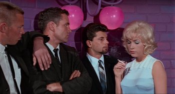 Movie still from “The Nutty Professor” (1963), directed by Jerry Lewis – A group of men and a woman standing next to each other; Medium shot, Low angle