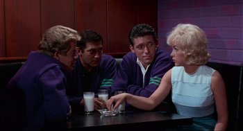 Movie still from “The Nutty Professor” (1963), directed by Jerry Lewis – A group of people sitting at a table with drinks; Medium shot, High angle