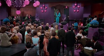 Movie still from “The Nutty Professor” (1963), directed by Jerry Lewis – A crowd of people are gathered around a stage; Extreme Wide shot, High angle