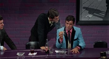 Movie still from “The Nutty Professor” (1963), directed by Jerry Lewis – Two men sitting at a table in front of a brick wall; Medium shot, Over the shoulder angle