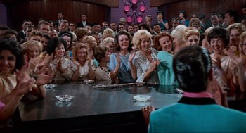 Movie still from “The Nutty Professor” (1963), directed by Jerry Lewis – A group of people sitting around a table; Wide shot, High angle