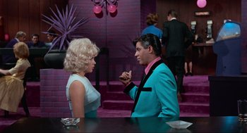 Movie still from “The Nutty Professor” (1963), directed by Jerry Lewis – A man and a woman are talking at a party; Medium shot, Over the shoulder angle