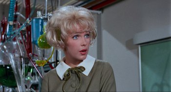Movie still from “The Nutty Professor” (1963), directed by Jerry Lewis – A woman with blonde hair and a green bow tie; Close Up shot, Low angle