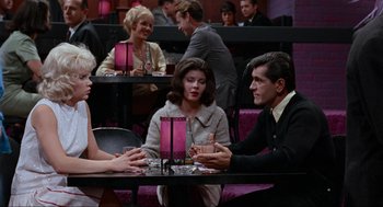 Movie still from “The Nutty Professor” (1963), directed by Jerry Lewis – A group of people sitting at a table in a restaurant; Medium shot, Over the shoulder angle