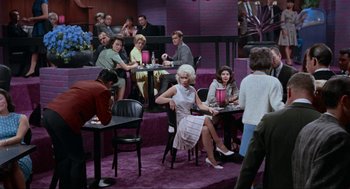 Movie still from “The Nutty Professor” (1963), directed by Jerry Lewis – A group of people sitting at tables in a room; Wide shot, High angle