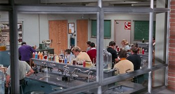 Movie still from “The Nutty Professor” (1963), directed by Jerry Lewis – A group of people sitting at a table in a room; Wide shot, High angle