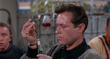 Movie still from “The Nutty Professor” (1963), directed by Jerry Lewis – A person holding a glass; Close Up shot, High angle