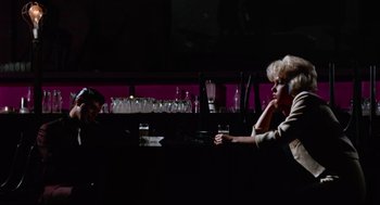 Movie still from “The Nutty Professor” (1963), directed by Jerry Lewis – Two people sitting at a bar with wine glasses on the table; Wide shot, High angle