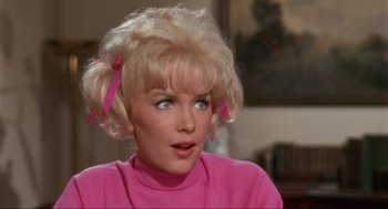 Movie still from “The Nutty Professor” (1963), directed by Jerry Lewis – A woman with blonde hair wearing a pink sweater; Close Up shot, Over the shoulder angle