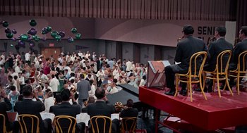 Movie still from “The Nutty Professor” (1963), directed by Jerry Lewis – A man playing a musical instrument in front of an audience; Extreme Wide shot, High angle