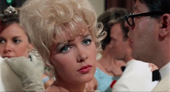 Movie still from “The Nutty Professor” (1963), directed by Jerry Lewis – A person wearing a blonde wig; Close Up shot, Over the shoulder angle