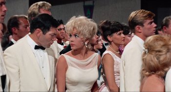 Movie still from “The Nutty Professor” (1963), directed by Jerry Lewis – A group of people standing around each other in formal wear; Medium shot, Low angle