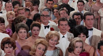 Movie still from “The Nutty Professor” (1963), directed by Jerry Lewis – A crowd of people in formal wear posing for a picture; Medium shot, Low angle
