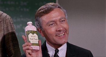 Movie still from “The Nutty Professor” (1963), directed by Jerry Lewis – A person holding a bottle of liquid; Close Up shot, High angle