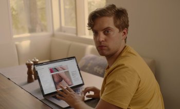 Movie still from “The One You're With” (2021), directed by C. Bailey Werner – A man sitting in front of a laptop computer; Extreme Close Up shot, Over the shoulder angle