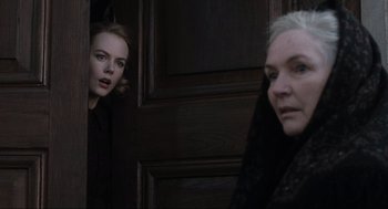 Movie still from “The Others” (2001), directed by Alejandro Amenábar – Two women are standing next to each other in front of a door; Close Up shot, Over the shoulder angle