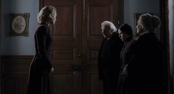 Movie still from “The Others” (2001), directed by Alejandro Amenábar – A group of people standing next to each other in front of a door; Medium shot, Over the shoulder angle