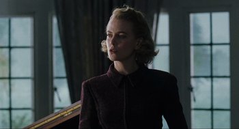 Movie still from “The Others” (2001), directed by Alejandro Amenábar – A woman with blonde hair wearing a burgundy jacket; Medium shot, Low angle