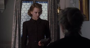 Movie still from “The Others” (2001), directed by Alejandro Amenábar – A woman in a black dress holding a cell phone; Medium shot, Over the shoulder angle