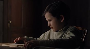 Movie still from “The Others” (2001), directed by Alejandro Amenábar – A young boy sitting in front of a laptop computer; Close Up shot, Low angle
