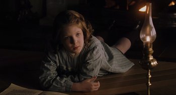 Movie still from “The Others” (2001), directed by Alejandro Amenábar – A young girl laying on the ground in a room; Close Up shot, High angle