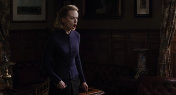 Movie still from “The Others” (2001), directed by Alejandro Amenábar – A woman in a dark room holding a suitcase; Medium shot, Low angle