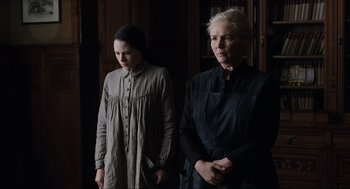 Movie still from “The Others” (2001), directed by Alejandro Amenábar – Two women standing next to each other in front of a window; Medium shot, Low angle