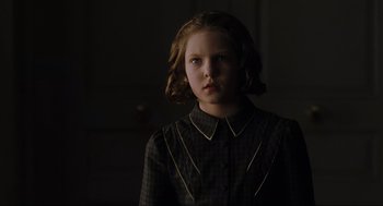 Movie still from “The Others” (2001), directed by Alejandro Amenábar – A young girl in a dark room looking at the camera; Close Up shot, Over the shoulder angle