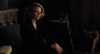 Movie still from “The Others” (2001), directed by Alejandro Amenábar – A woman sitting in front of a microphone in a dark room; Medium shot, Low angle