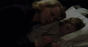 Movie still from “The Others” (2001), directed by Alejandro Amenábar – A woman and a child laying in a bed together; Close Up shot, High angle