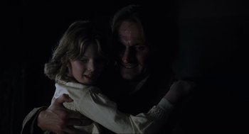 Movie still from “The Others” (2001), directed by Alejandro Amenábar – A man and a girl are hugging in the dark; Close Up shot, Over the shoulder angle