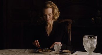 Movie still from “The Others” (2001), directed by Alejandro Amenábar – A woman sitting at a table with a plate of food in front of her; Medium shot, High angle
