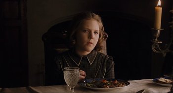 Movie still from “The Others” (2001), directed by Alejandro Amenábar – A girl sitting in front of a plate of food; Medium shot, Over the shoulder angle