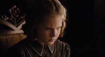 Movie still from “The Others” (2001), directed by Alejandro Amenábar – A little girl is looking down at the ground; Close Up shot, Over the shoulder angle