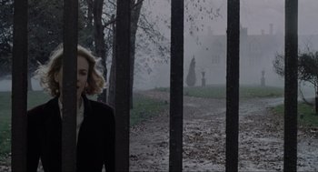 Movie still from “The Others” (2001), directed by Alejandro Amenábar – A woman in a black jacket walking through a park; Extreme Wide shot, Low angle