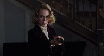 Movie still from “The Others” (2001), directed by Alejandro Amenábar – A woman holding a remote in her hand; Medium shot, Low angle