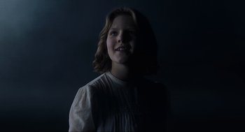 Movie still from “The Others” (2001), directed by Alejandro Amenábar – A young girl in a white dress smiling for the camera; Close Up shot, Low angle
