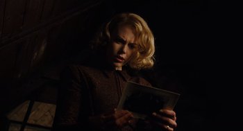 Movie still from “The Others” (2001), directed by Alejandro Amenábar – A woman looking at an image in a dark room; Close Up shot, Low angle