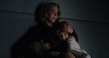 Movie still from “The Others” (2001), directed by Alejandro Amenábar – A woman and two children in a dark room; Medium shot, Low angle