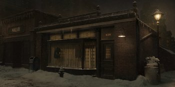 Movie still from “The Outfit” (2022), directed by Graham Moore – A building with a fire hydrant in front of it at night; Extreme Wide shot, High angle