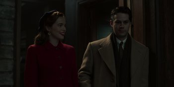 Movie still from “The Outfit” (2022), directed by Graham Moore – A man and a woman standing next to each other; Medium shot, Over the shoulder angle