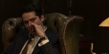 Movie still from “The Outfit” (2022), directed by Graham Moore – A man sitting in a chair with his hand to his face; Close Up shot, Low angle
