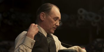 Movie still from “The Outfit” (2022), directed by Graham Moore – An older man wearing a tie and a vest; Close Up shot, Low angle