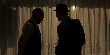 Movie still from “The Outfit” (2022), directed by Graham Moore – Two men in suits and a hat are facing each other; Medium shot, Low angle