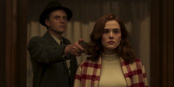 Movie still from “The Outfit” (2022), directed by Graham Moore – A woman getting her hair cut by a man in a suit; Medium shot, Over the shoulder angle