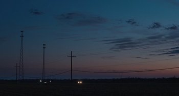 Movie still from “The Passenger” (2023), directed by Carter Smith – Two cars are parked in the middle of a field at night; Extreme Wide shot, Low angle